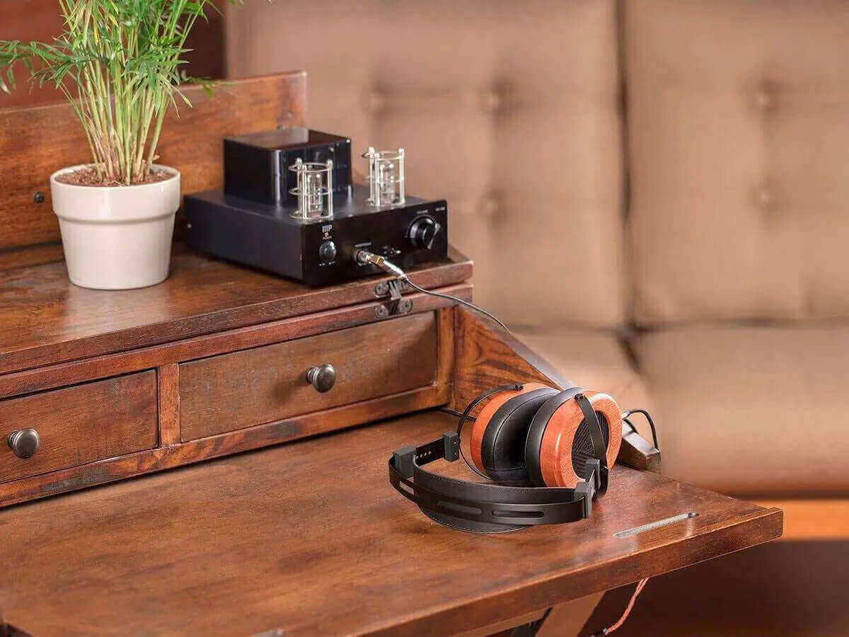Monolith M565 headphones on a wooden desk with an amplifier, highlighting the 6th of January sale.