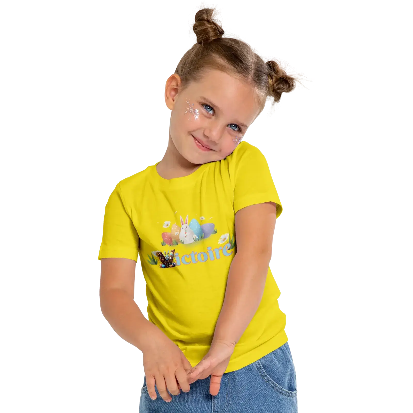 Young girl in a bright yellow t-shirt with playful graphics, smiling and posing cheerfully.