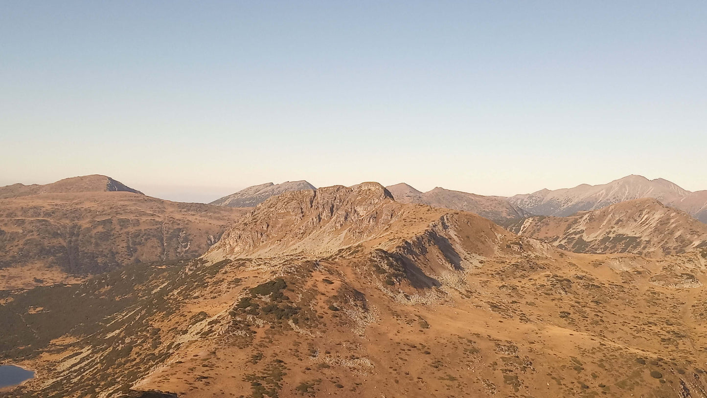 Aerial view of a rugged mountain range bathed in warm sunset light